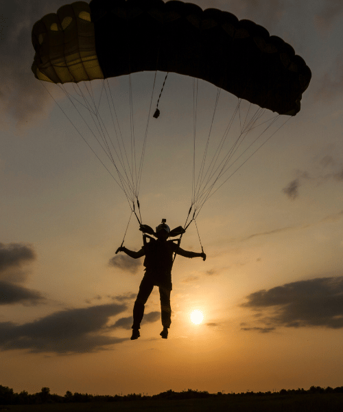 Solo skydiver gliding above Patagonia’s dramatic landscape – snow-capped peaks, rugged terrain, and pristine wilderness