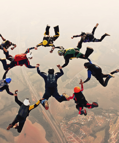 Group of skydivers in freefall forming a circle – extreme adventure and teamwork high above the clouds