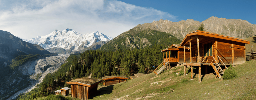 A peaceful campfire burning in Fairy Meadows, Pakistan, with a view of snow-covered Nanga Parbat under a starlit sky.
