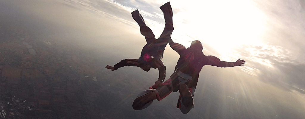 Skydiver above Queenstown, New Zealand with dramatic mountain peaks, blue lakes, and stunning South Island landscapes below