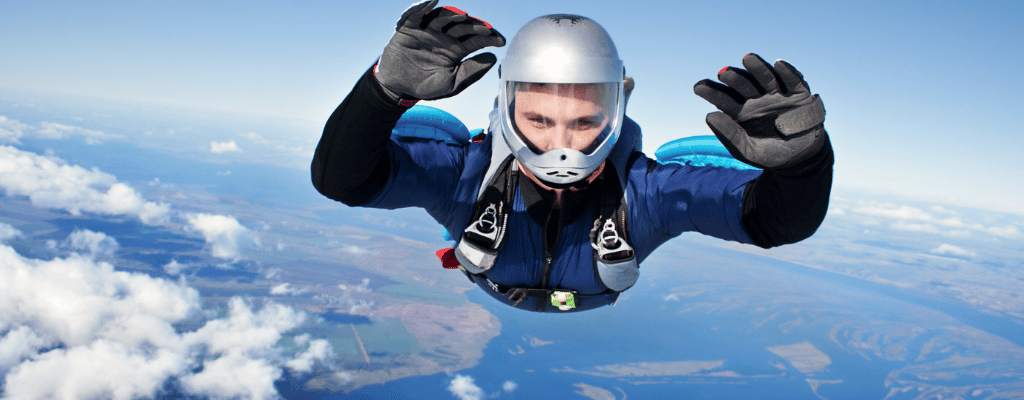 Skydiver freefalling over Oahu, Hawaii with a stunning aerial view of beaches, ocean waves, and volcanic terrain below