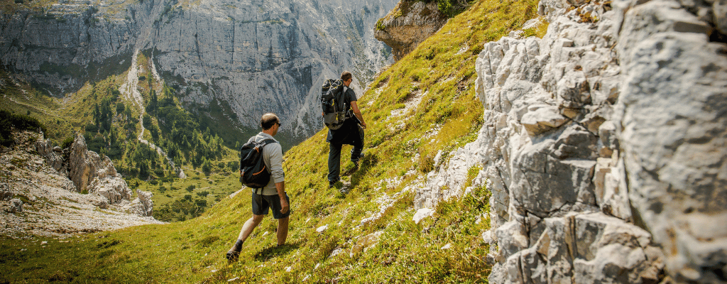 Two hikers trekking along a scenic mountain trail in the Dolomites, Italy – a breathtaking alpine hiking paradise in the Alps