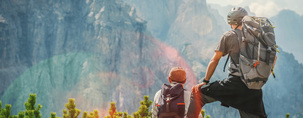 Two people hiking through the stunning wilderness of Banff and Jasper National Parks in Canada, surrounded by alpine lakes, pine forests, and majestic mountains