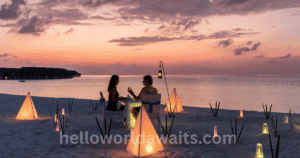 Romantic beachside dinner setup at sunset — a famous honeymoon destination capturing an intimate moment for newlyweds.