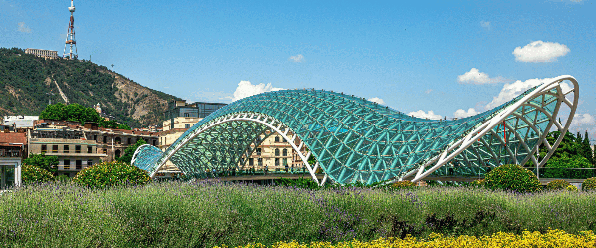 Bridge of Peace in Tbilisi Georgia with Mtatsminda Park and TV Tower in the background.