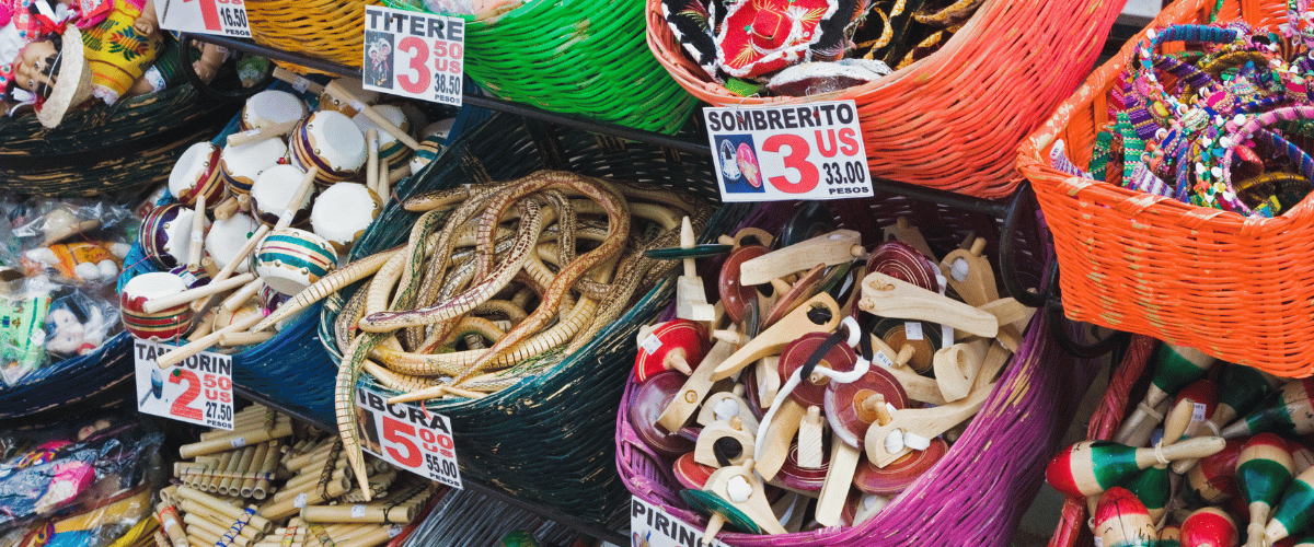 Silhouette of people with raised hands holding green and white glow sticks at a music festival.