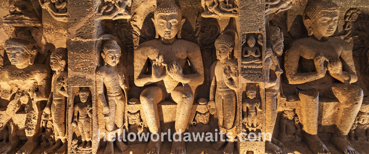 Intricate rock-cut sculptures of seated Buddha figures carved into the basalt cliff facade of the Ajanta Caves, a UNESCO World Heritage site in Maharashtra, India.