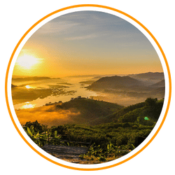 A high-angle view of a misty river valley at sunrise in Laos, with the sun reflecting off the winding water and golden light illuminating the fog-covered hills and lush green fields.