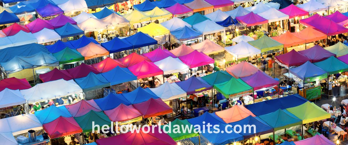 Bird's eye view of vibrant, colorful vendor tents at a busy night market, showcasing a variety of stalls and local street food culture