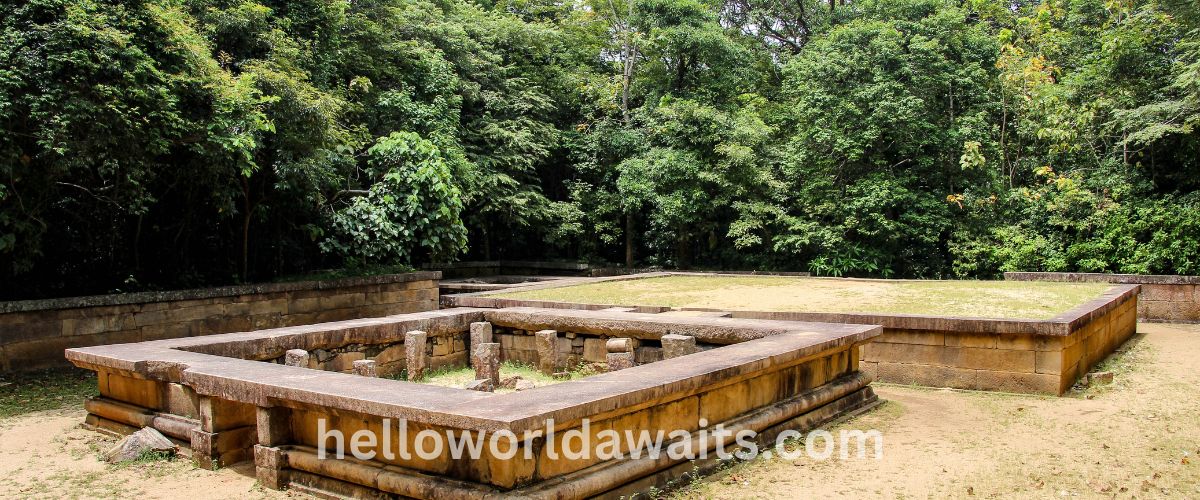 The ancient Kuttam Pokuna (Twin Ponds) stone bathing pools in Anuradhapura, Sri Lanka. The image shows the rectangular granite structures and tiered stone walls surrounded by a lush green forest background.