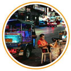 a shoapkeaper on thailand sitting on chair in front of his shop